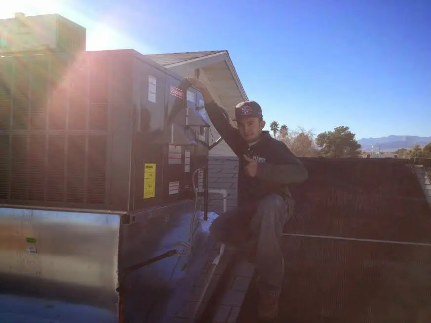 HVAC technician performing Air Duct Cleaning on a rooftop unit in Cicero